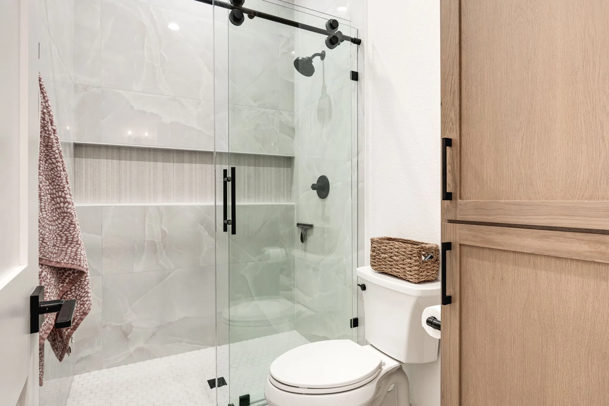 Bathroom featuring toilet and a marble finish shower