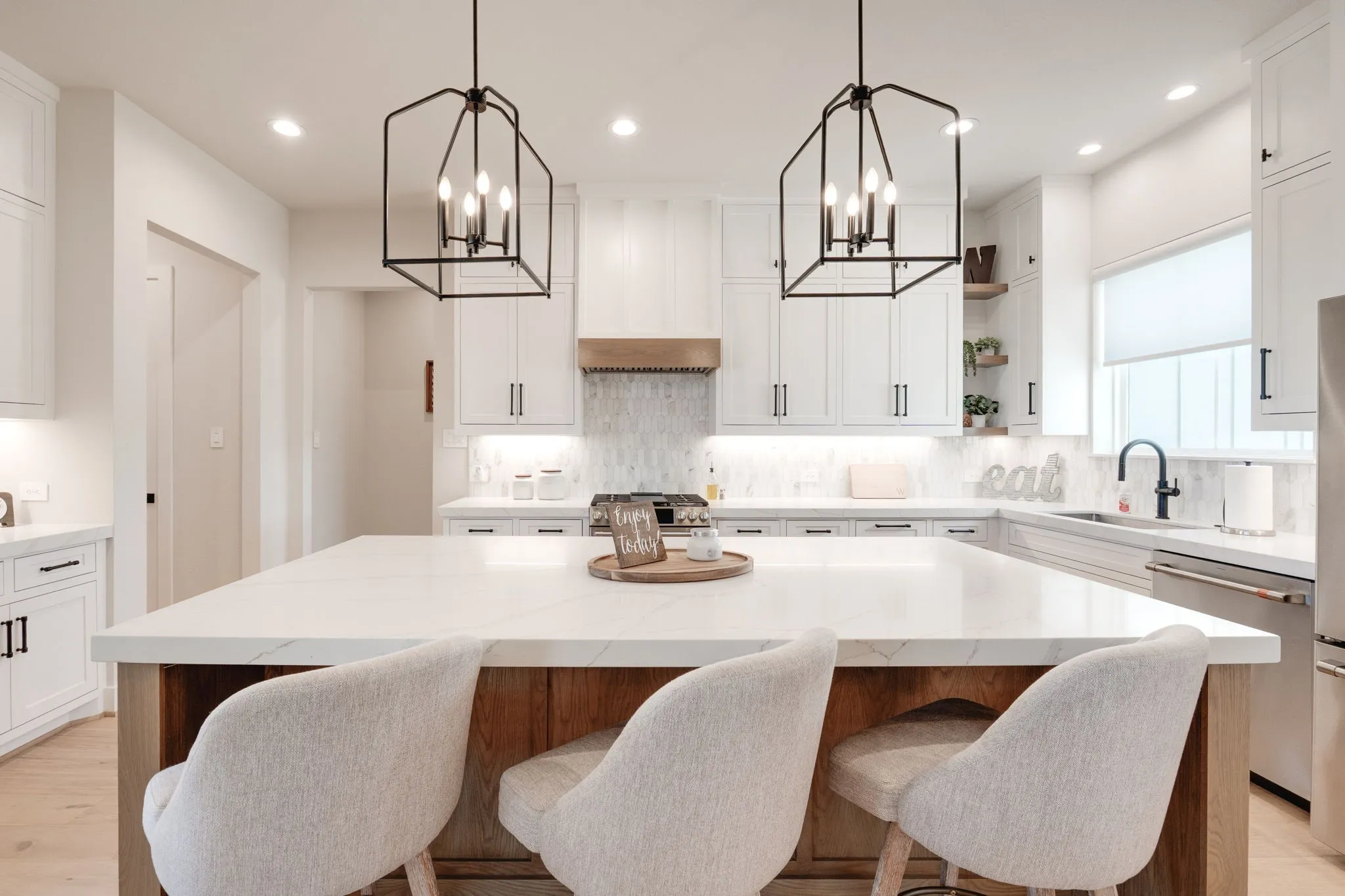 Kitchen with open shelves, a chandelier, stainless steel appliances, a kitchen island, and two tone cabinetry