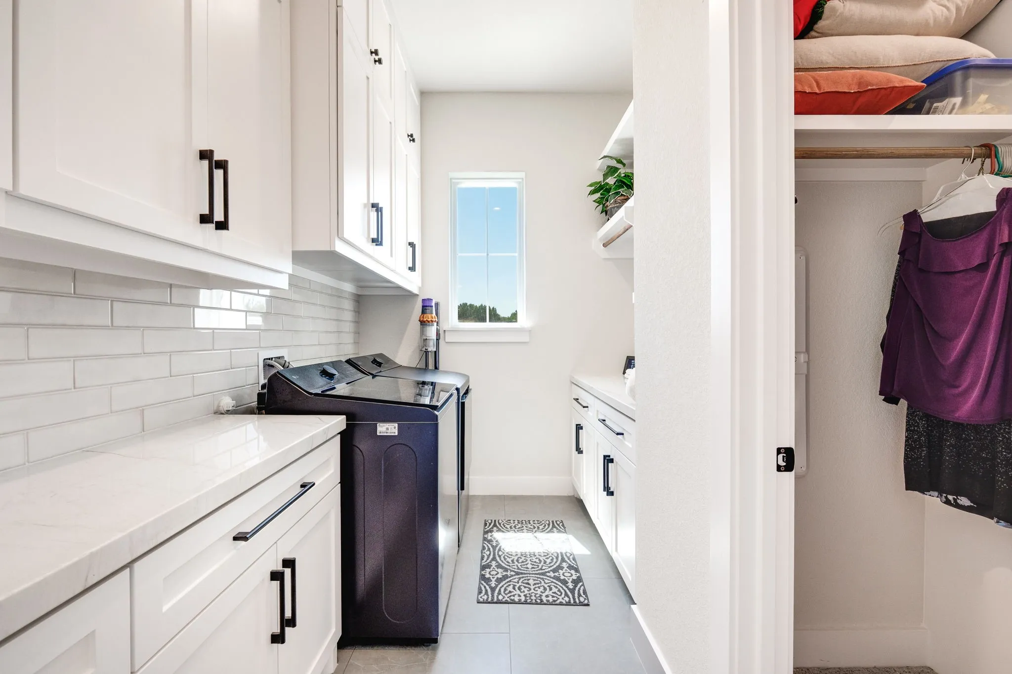 Laundry room with cabinet space, light tile patterned floors, and washer and dryer