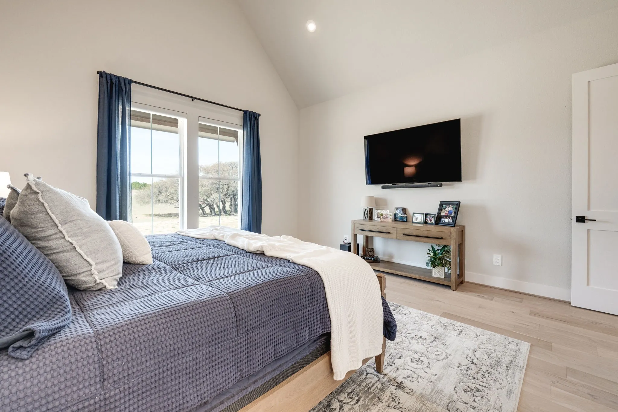 Bedroom with recessed lighting, light wood-style floors, and vaulted ceiling