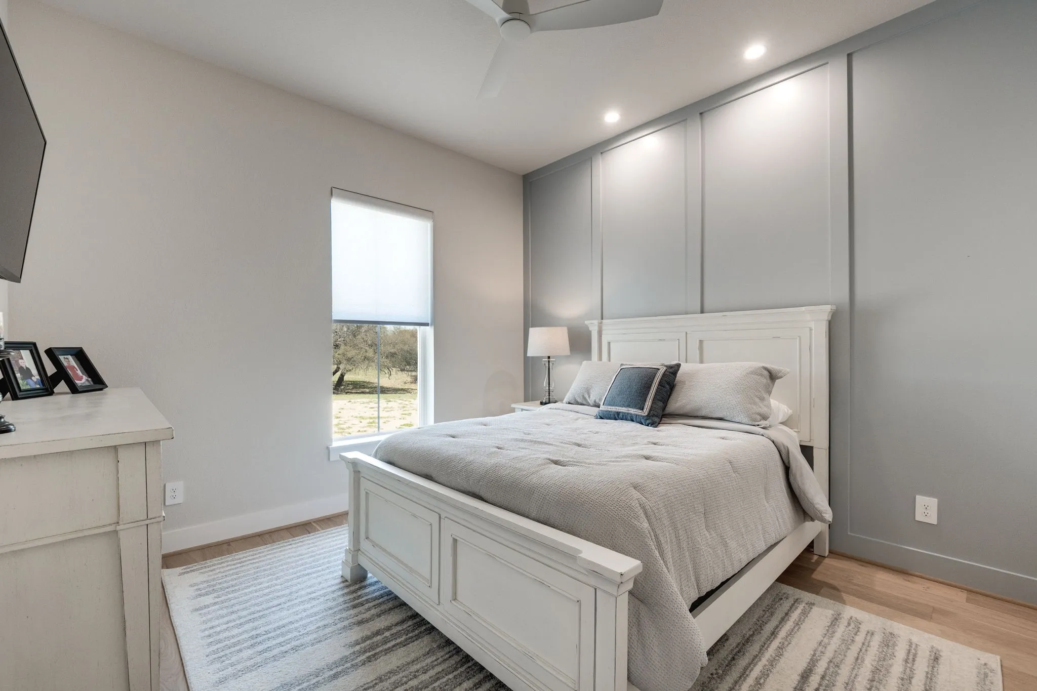 Bedroom featuring ceiling fan, light wood finished floors, recessed lighting, and a decorative wall
