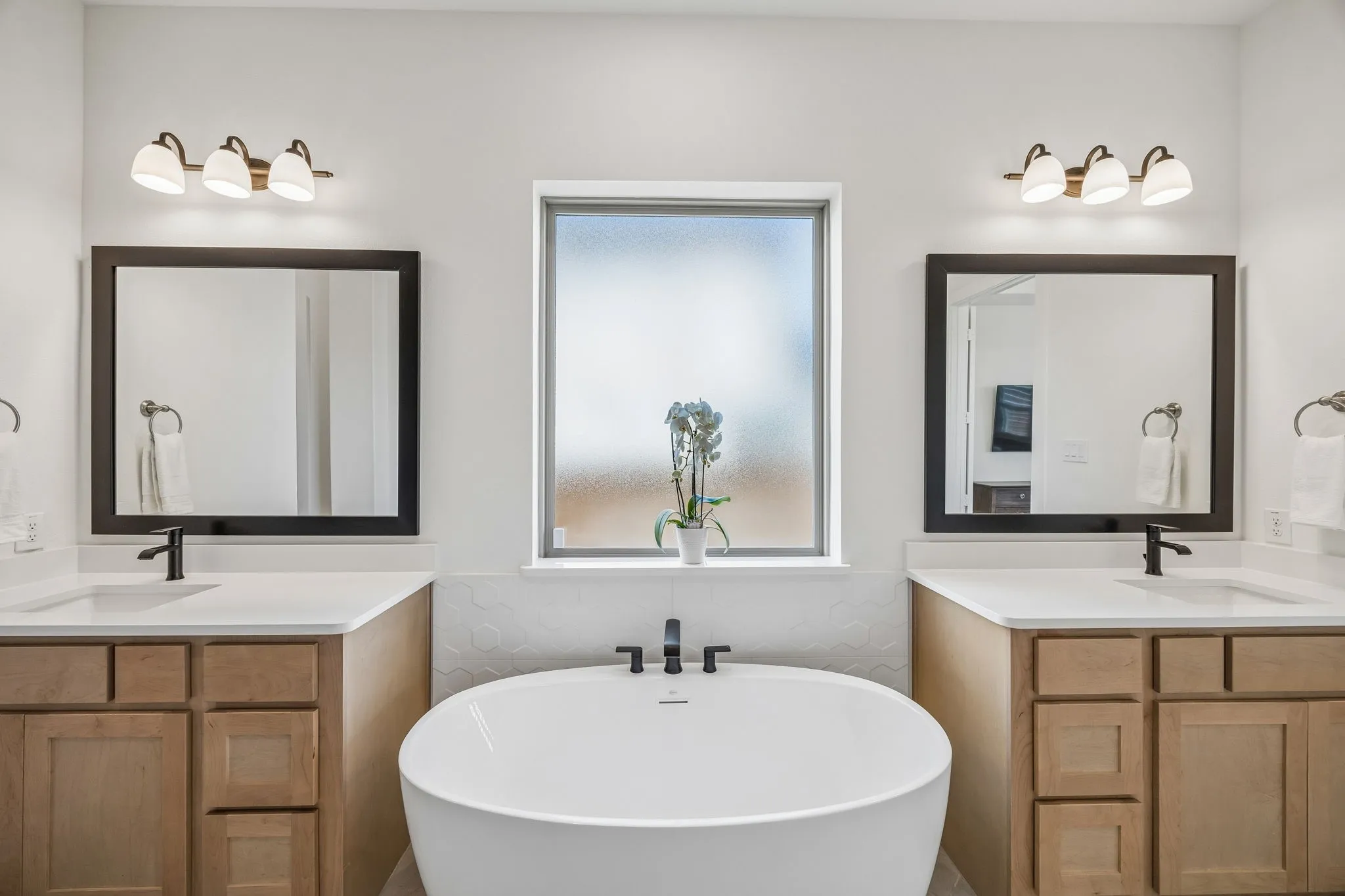 Full bath with a soaking tub and two vanities