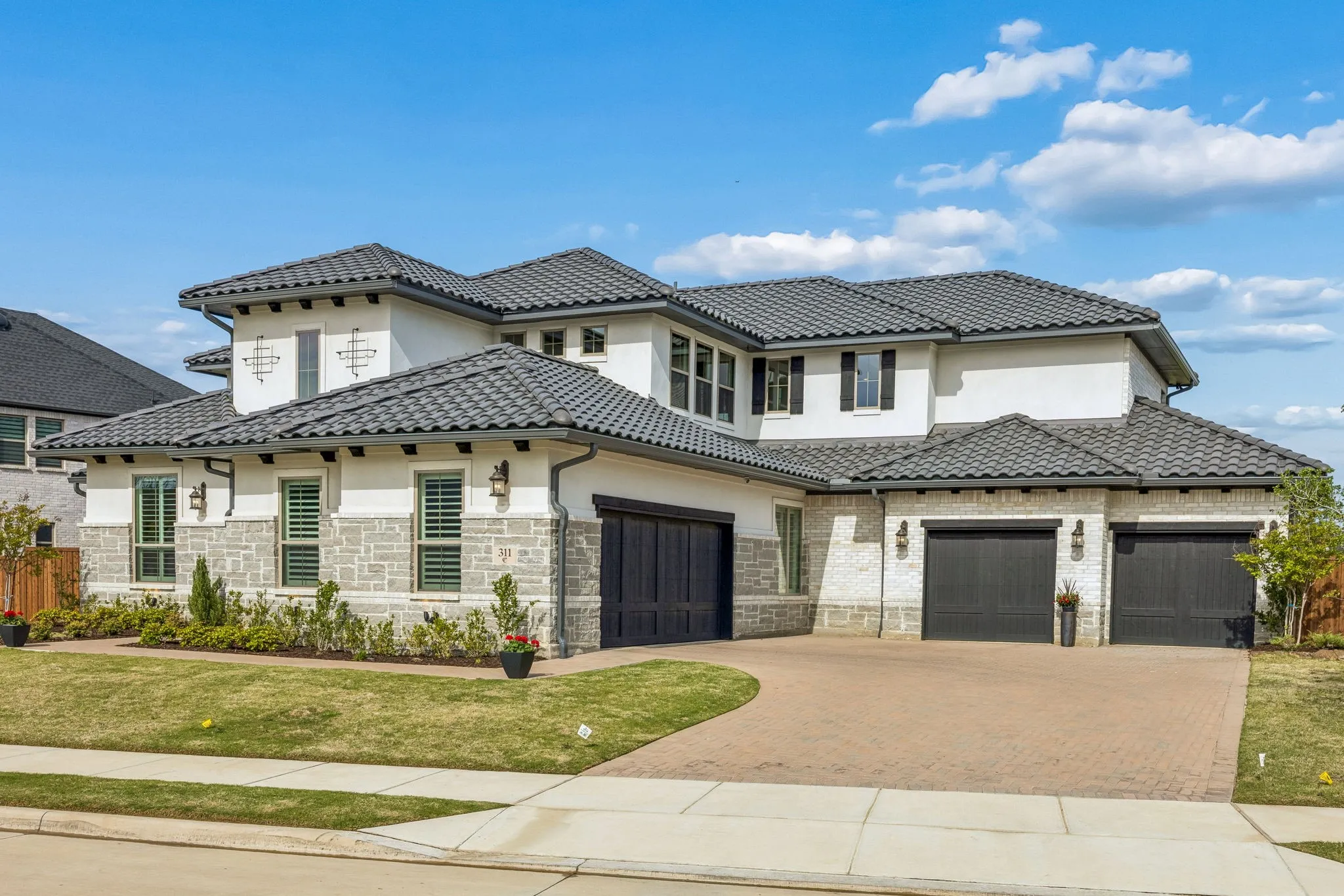 Mediterranean / spanish house featuring decorative driveway, a front yard, and a garage