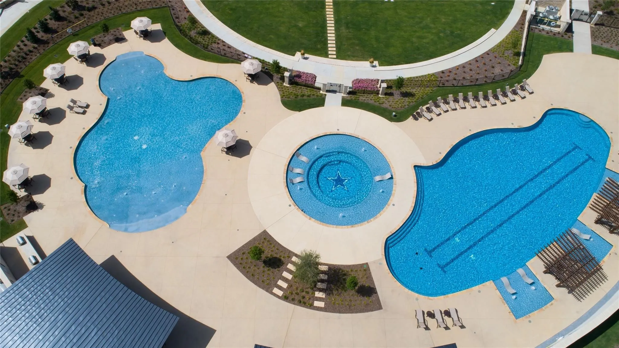 Expansive aquatic amenity featuring multiple pools, a circular spa, and surrounding hardscaping