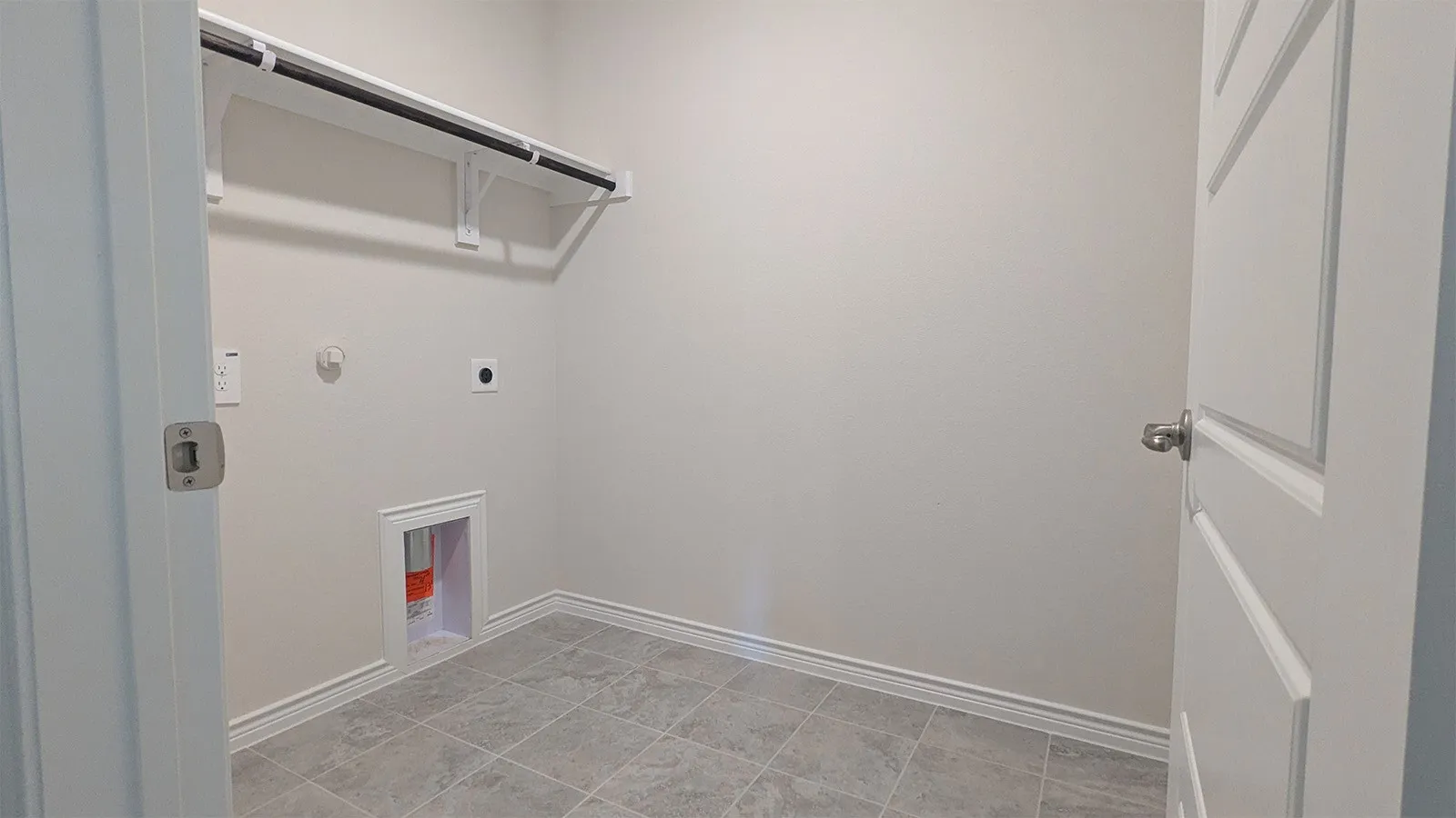 Utility room featuring light gray tile flooring and white baseboards