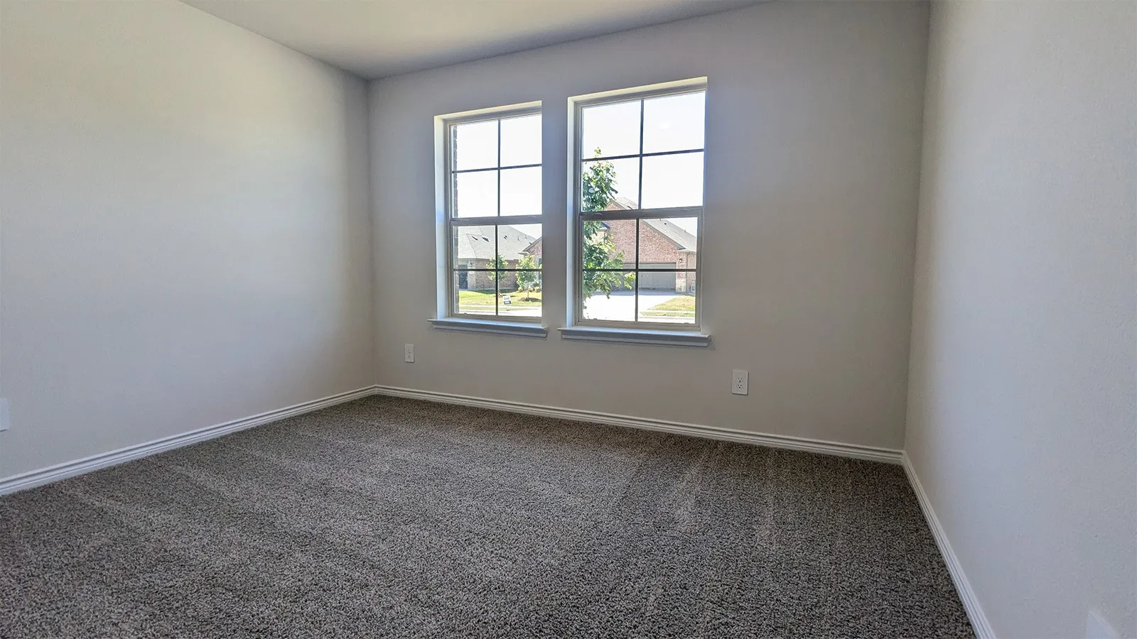 Neutral-toned carpeting paired with light gray walls and white baseboards