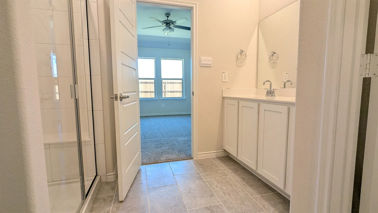 Bathroom featuring a spacious dual vanity with white cabinetry and a large mirror