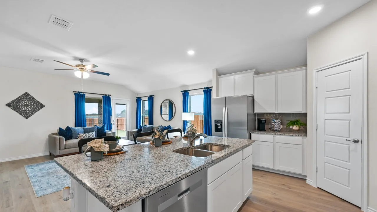 Kitchen with white cabinets, light stone counters, stainless steel appliances, light wood-style floors, and open floor plan