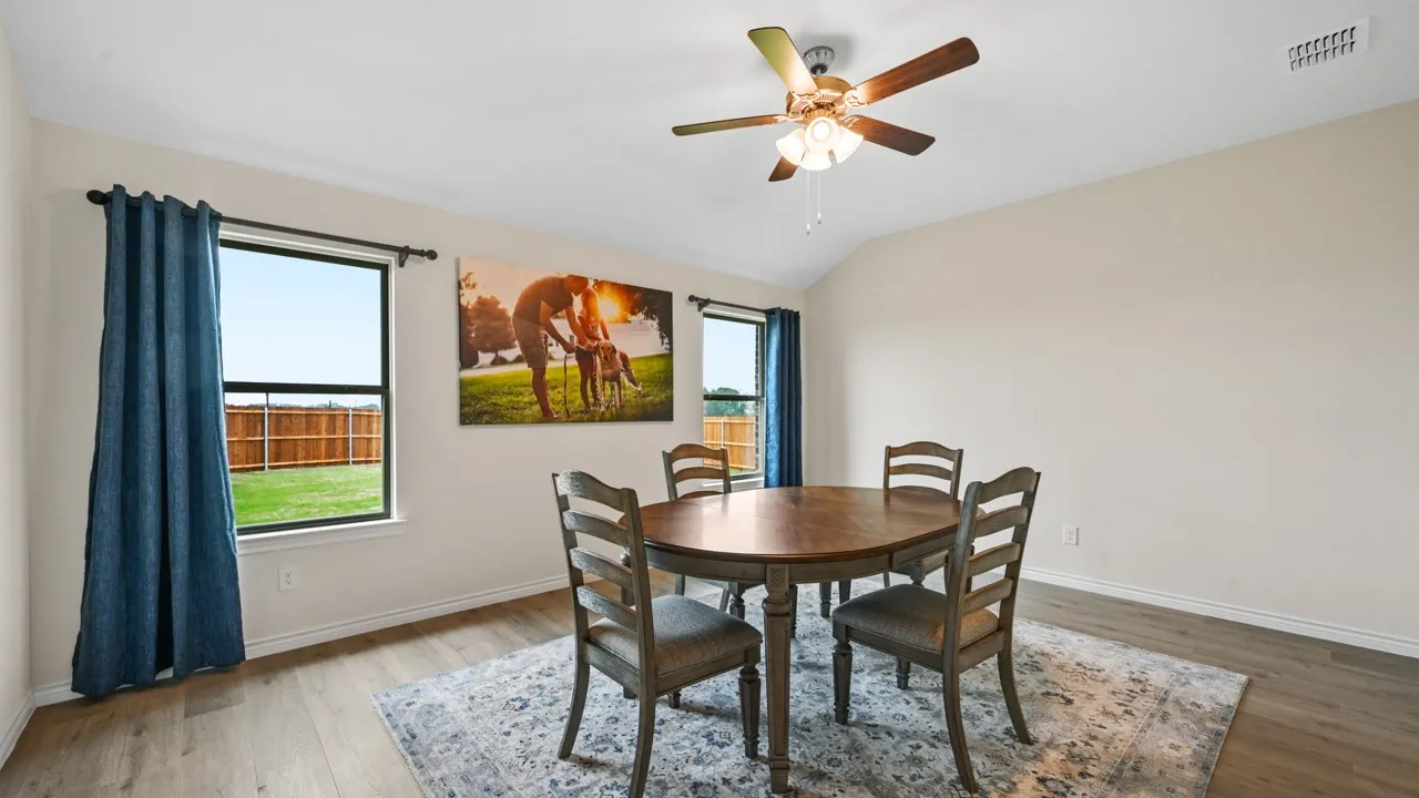 Dining area featuring light wood-style flooring, ceiling fan, and lofted ceiling