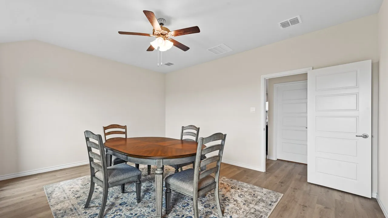 Dining space featuring ceiling fan, light wood-type flooring, and lofted ceiling