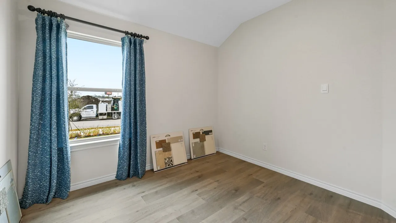 Unfurnished room with light wood-style floors and lofted ceiling