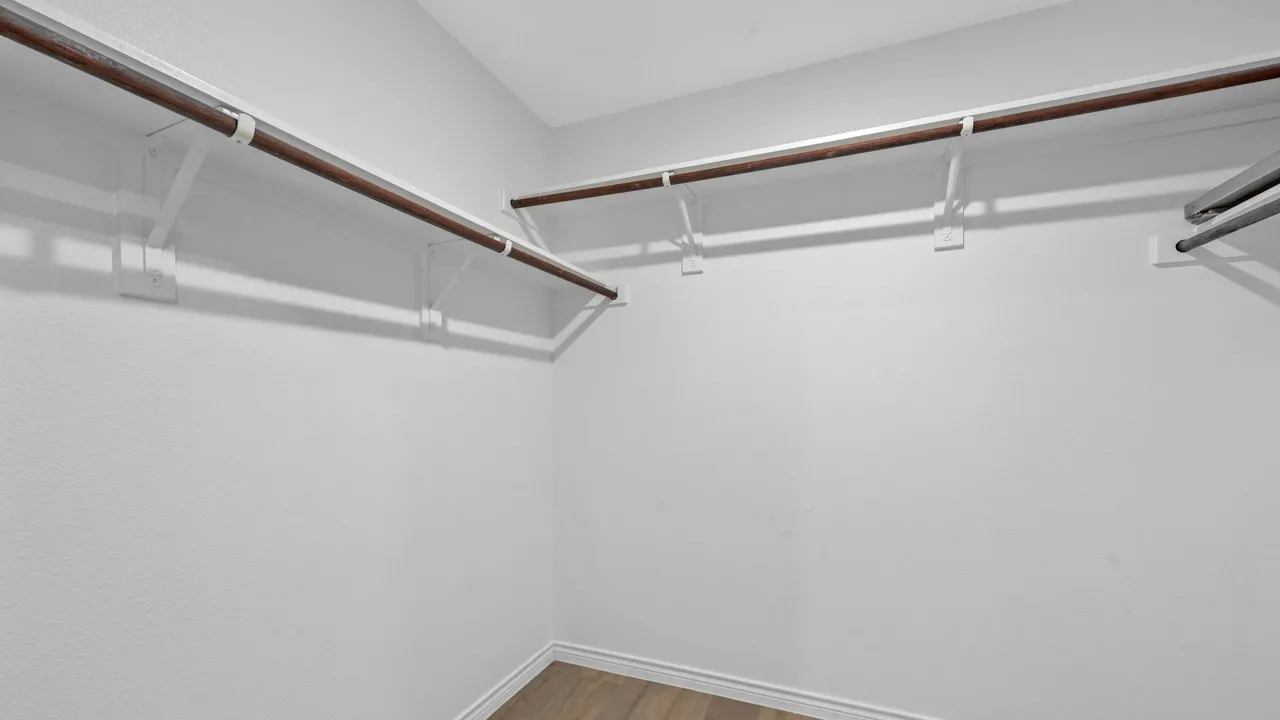 Walk in closet with light wood-type flooring