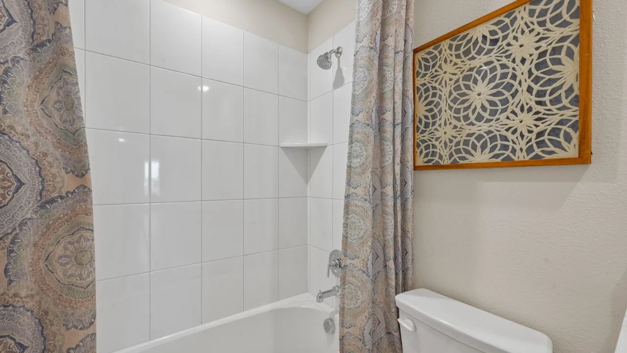 Full bath with shower / bath combination with curtain and a textured wall