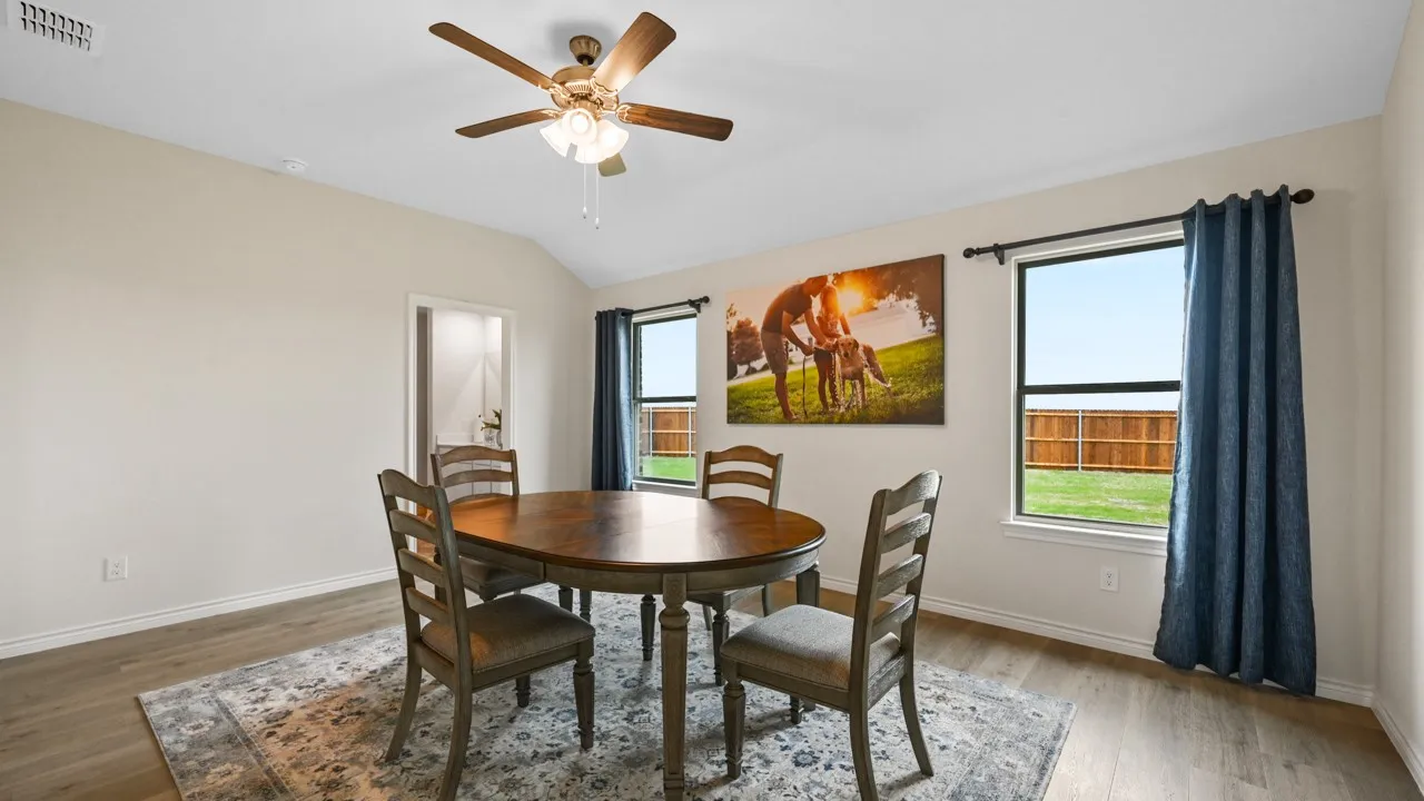 Dining space with healthy amount of natural light, light wood-style flooring, a ceiling fan, and vaulted ceiling
