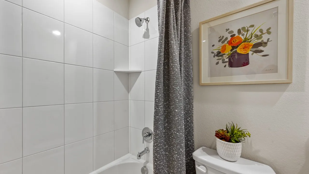 Full bathroom featuring shower / bath combination with curtain and a textured wall