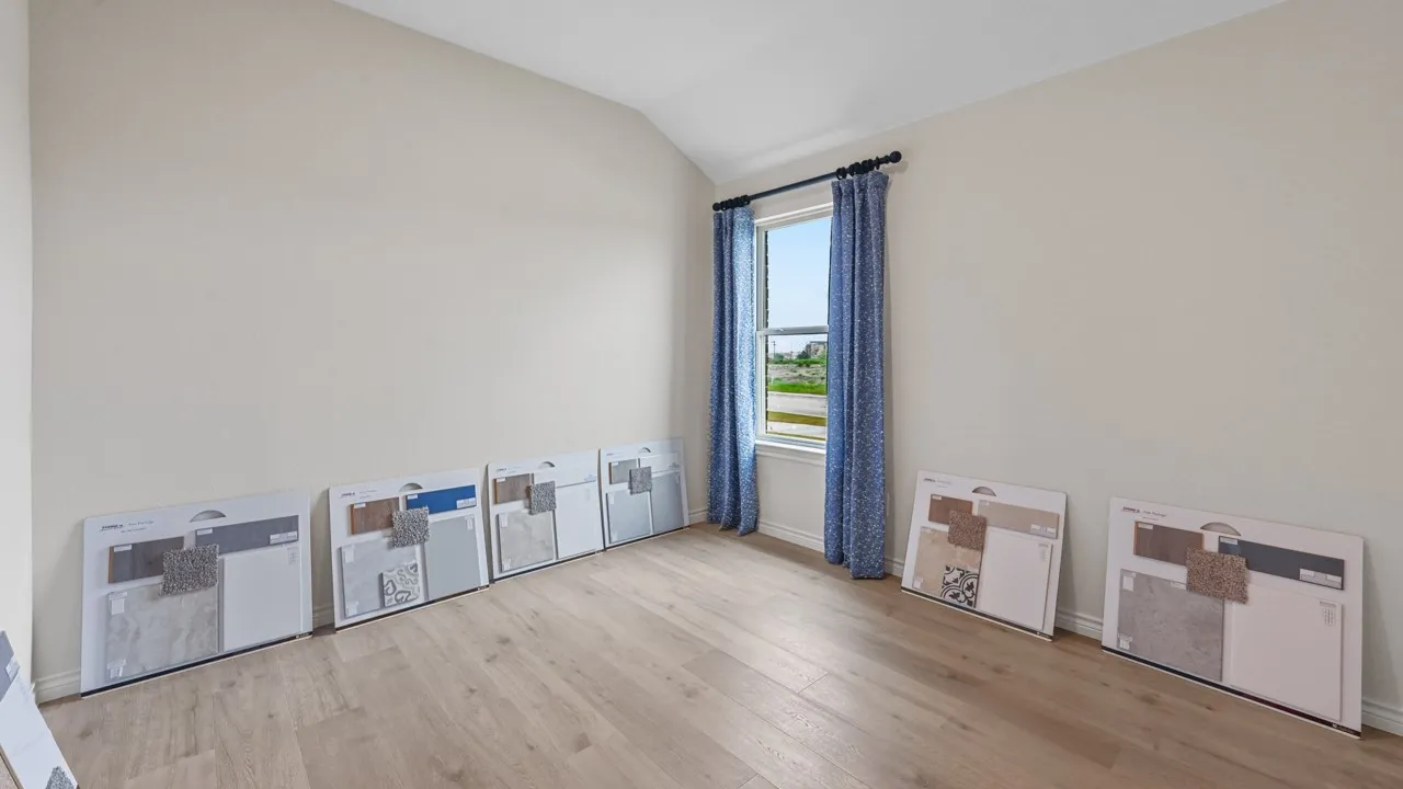 Unfurnished room featuring light wood finished floors and lofted ceiling
