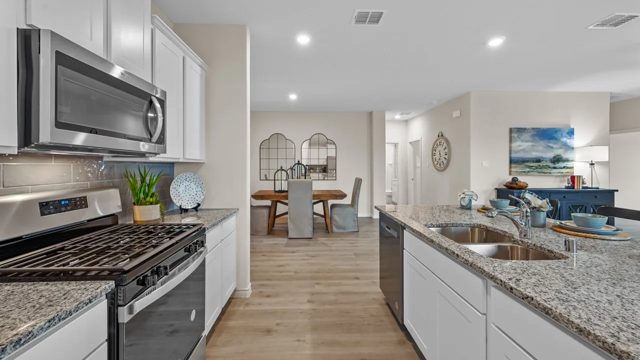 Kitchen with stainless steel appliances, white cabinetry, light wood finished floors, light stone countertops, and recessed​​‌​​​​‌​​‌‌​‌‌​​​‌‌​‌​‌​‌​​​‌​​ lighting