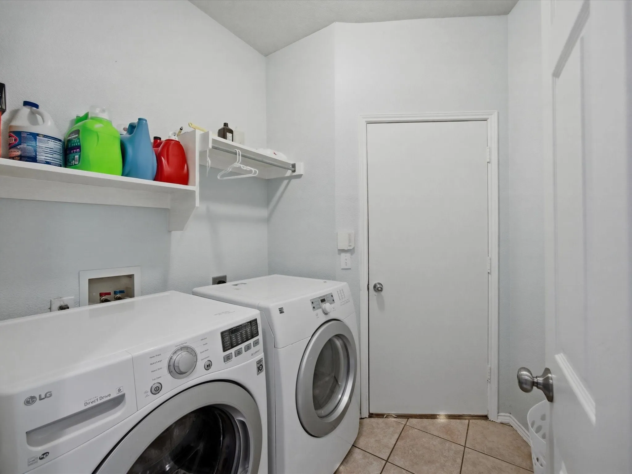 Laundry room featuring light tile patterned floors and washing machine and dryer