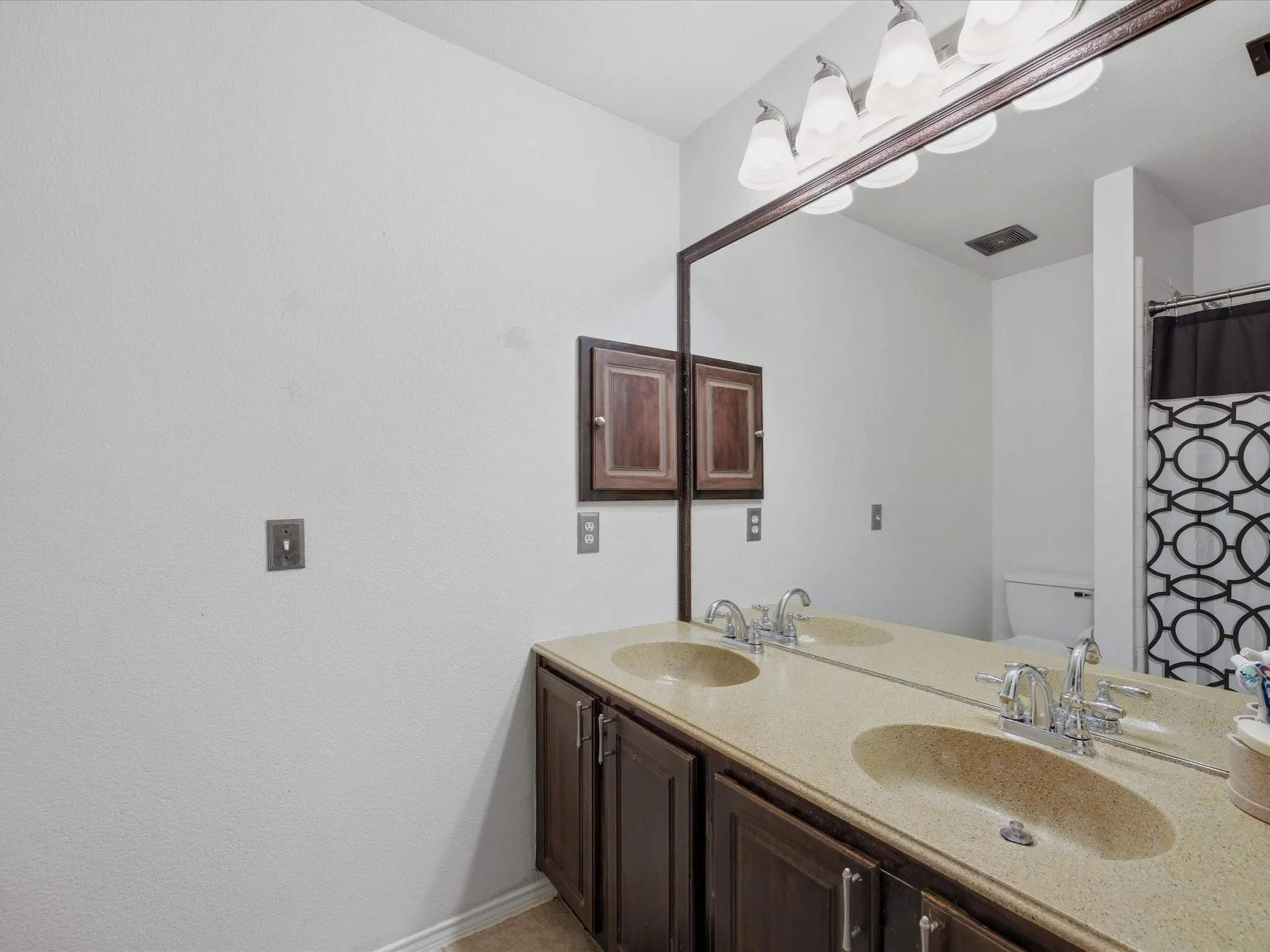 Guest bathroom with double vanity and a shower with shower curtain