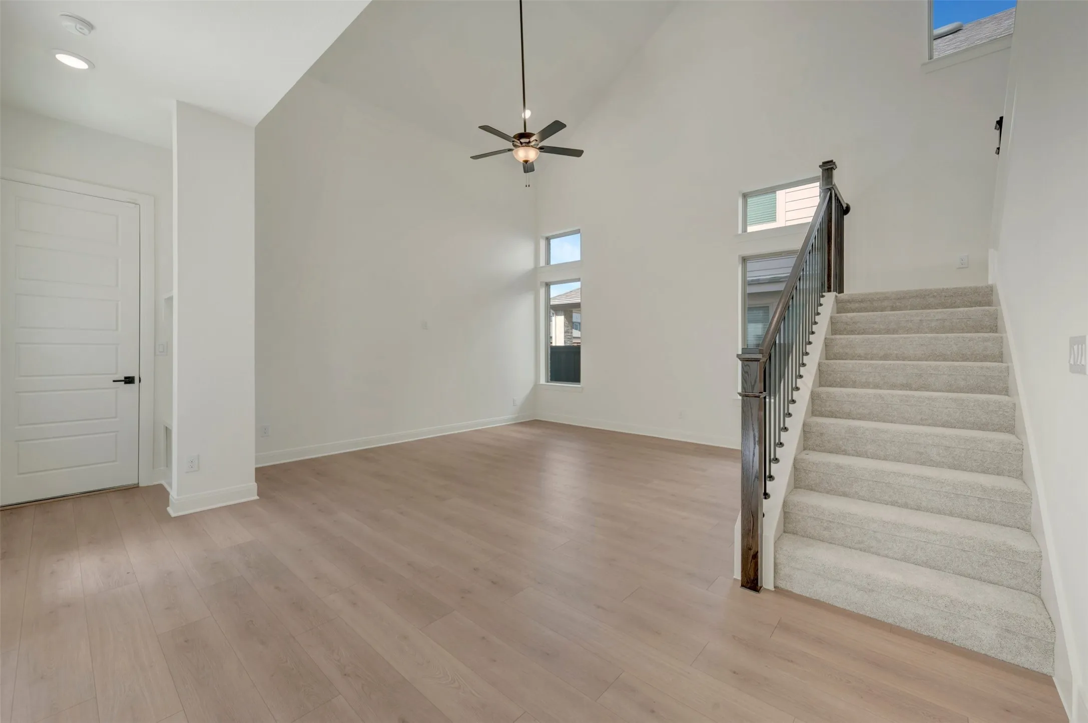 Expansive living area featuring soaring ceilings and wood-finish flooring