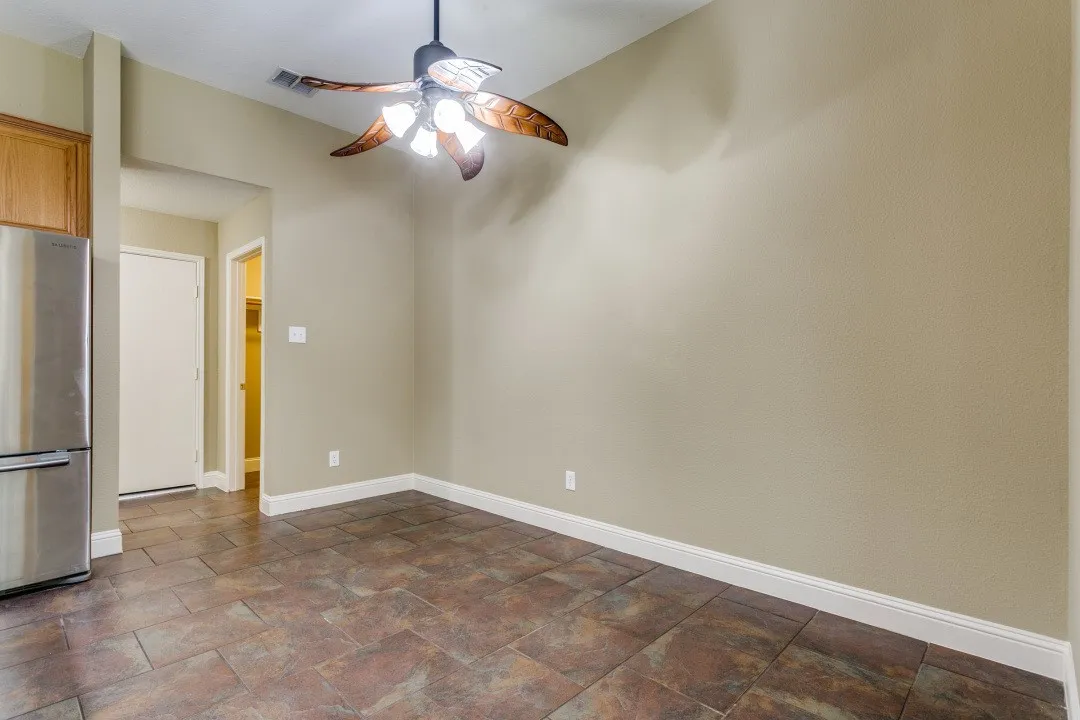 Unfurnished room featuring stone finish floors and a ceiling fan