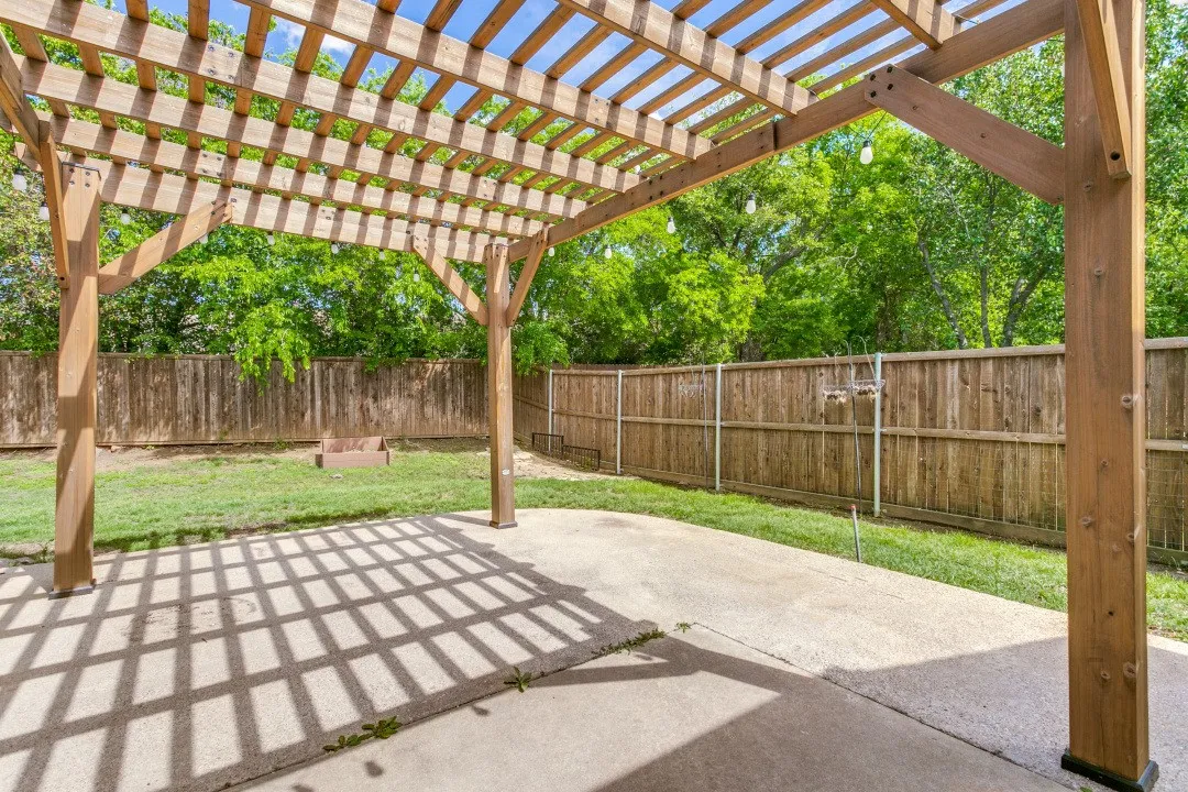 Fenced backyard featuring a pergola and a patio area