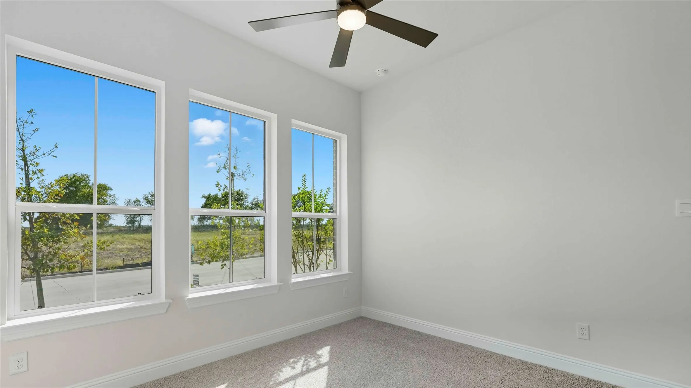 Unfurnished room featuring ceiling fan and light carpet
