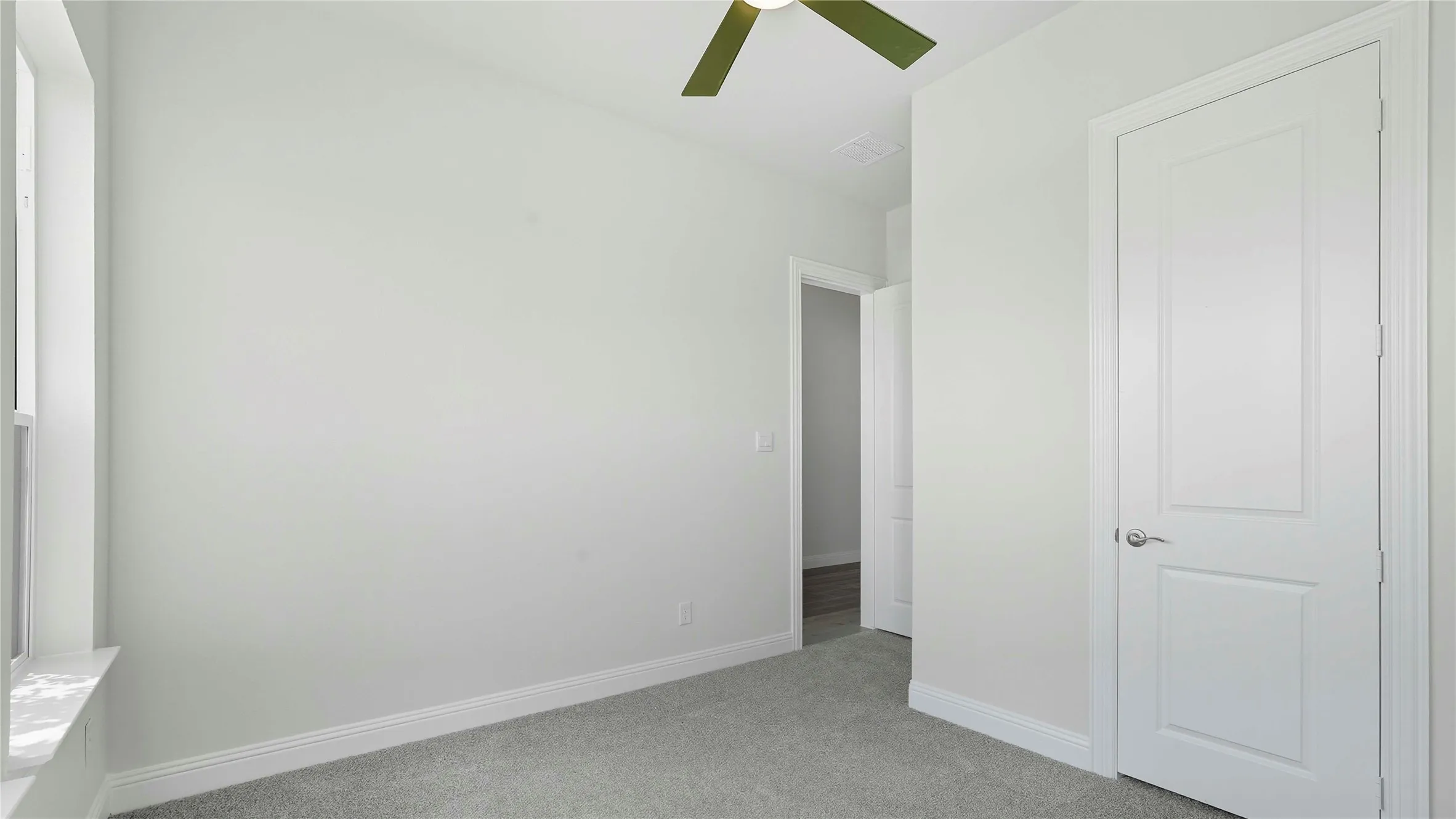 Unfurnished bedroom with light colored carpet and ceiling fan