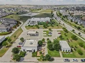 Aerial view of property and surrounding area featuring nearby suburban area