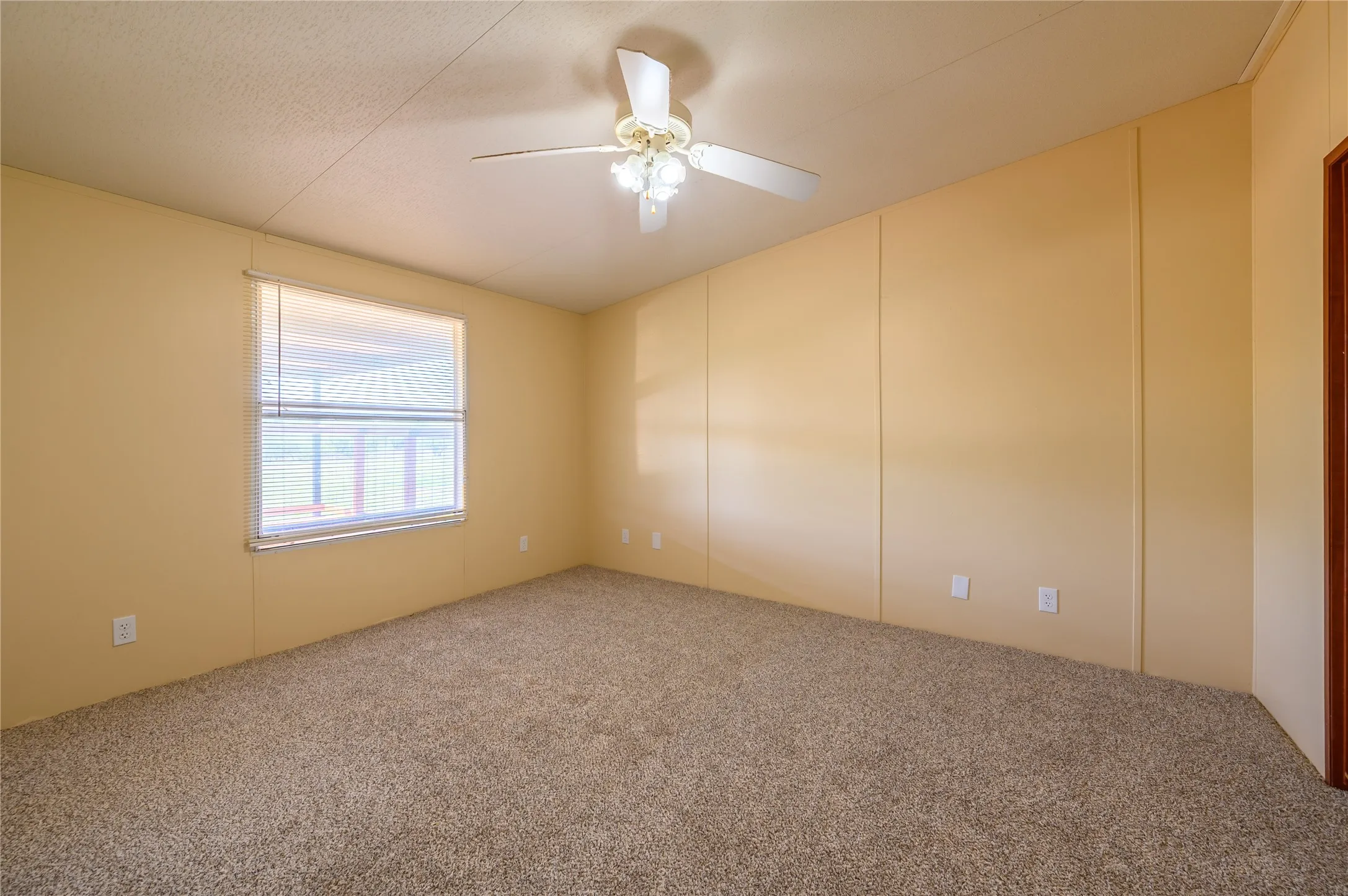 Carpeted empty room featuring ceiling fan