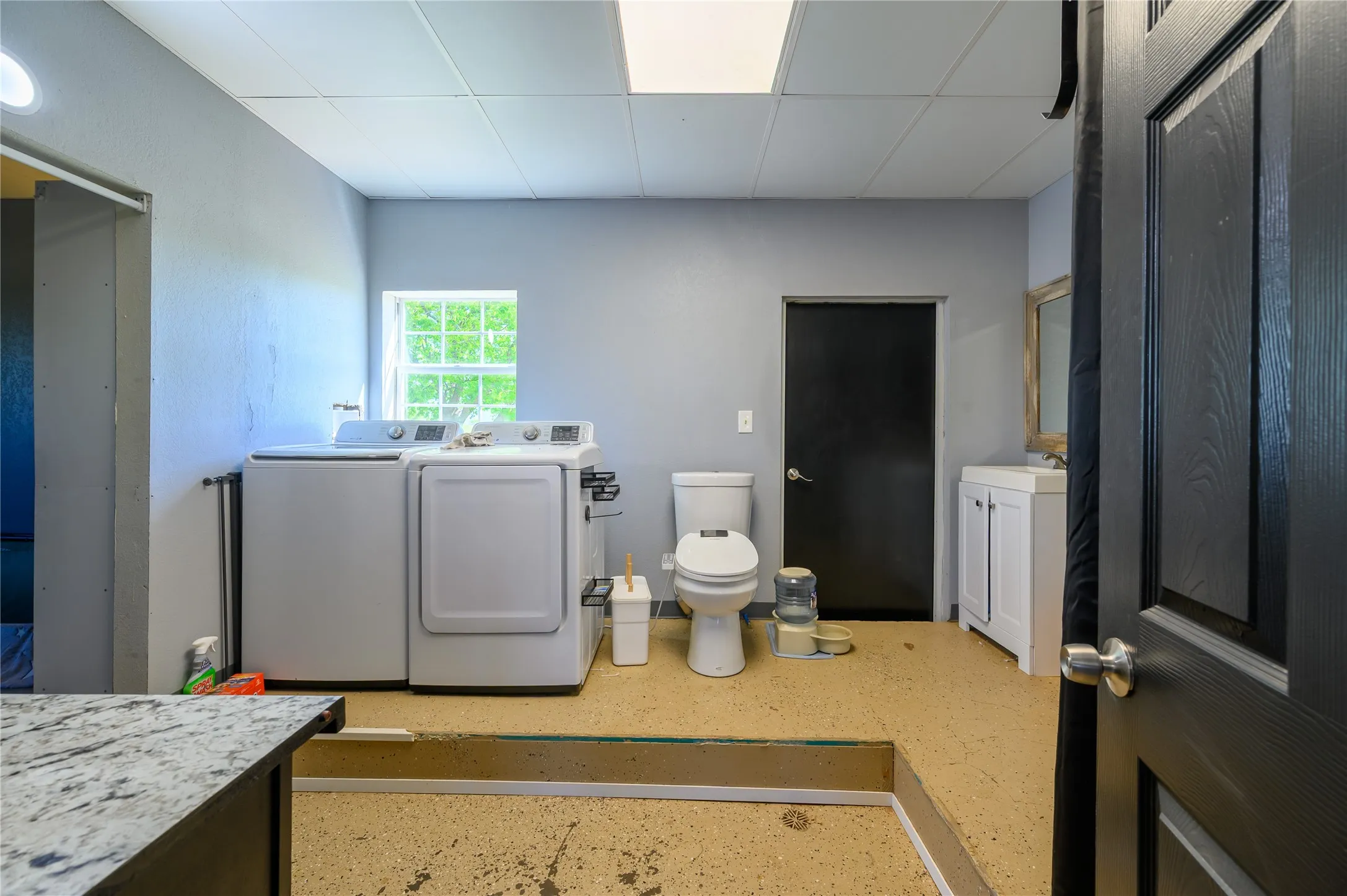 Bathroom with vanity, washer and dryer, and a paneled ceiling