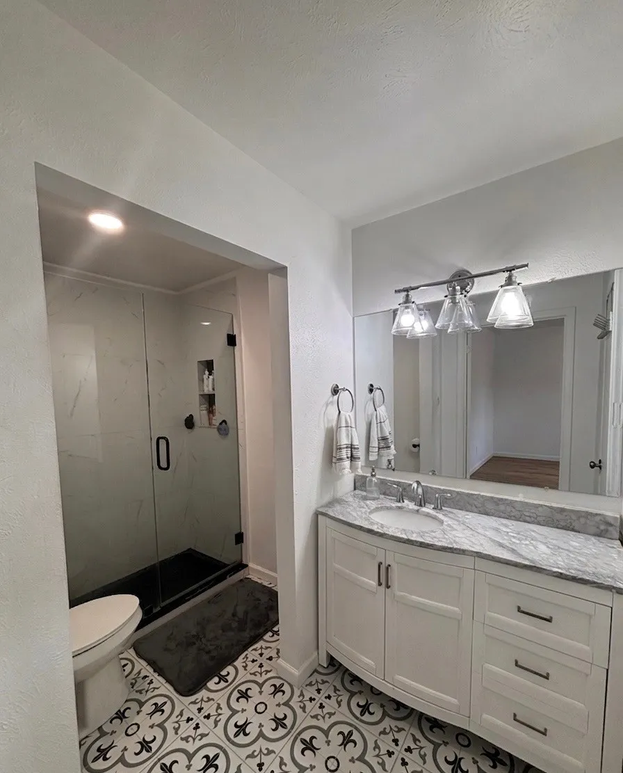 Full bathroom with vanity, a shower stall, and light tile patterned floors