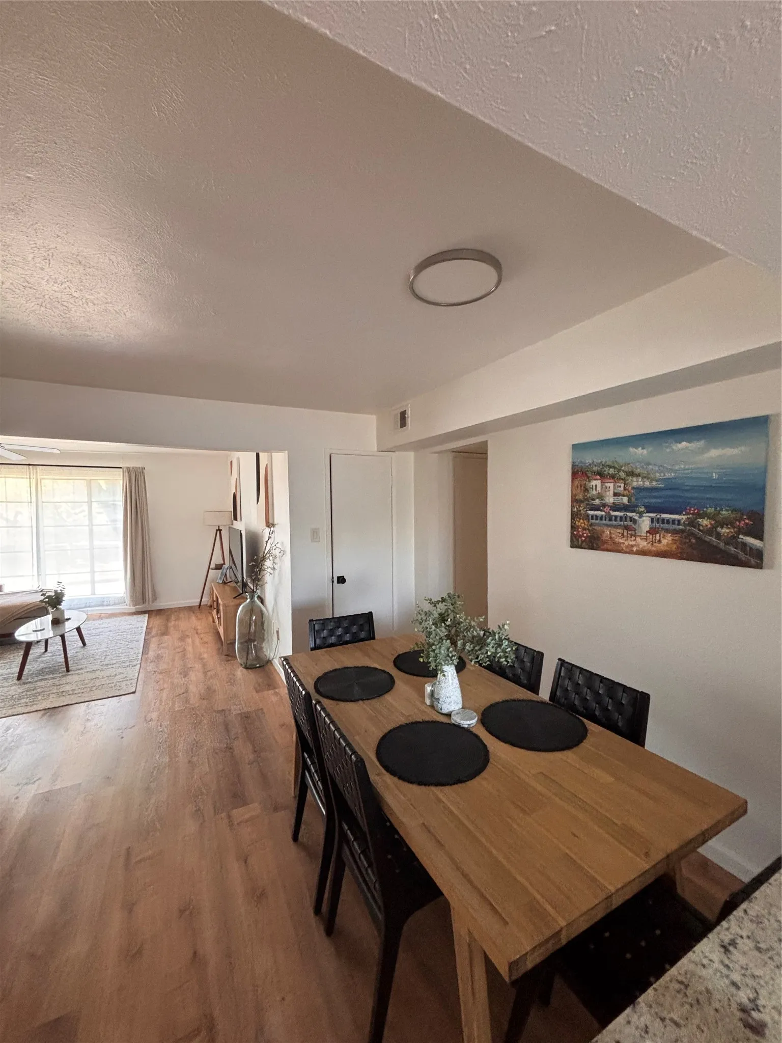 Dining area with a textured ceiling and wood finished floors