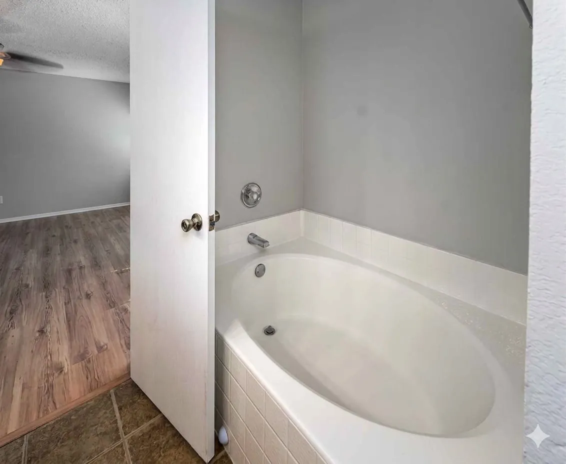 Bathroom with a bath, a textured ceiling, ceiling fan, and dark tile patterned floors