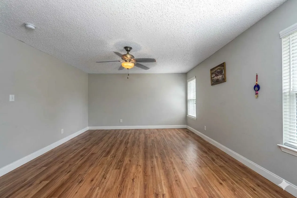 Spare room with wood finished floors, ceiling fan, and a textured ceiling