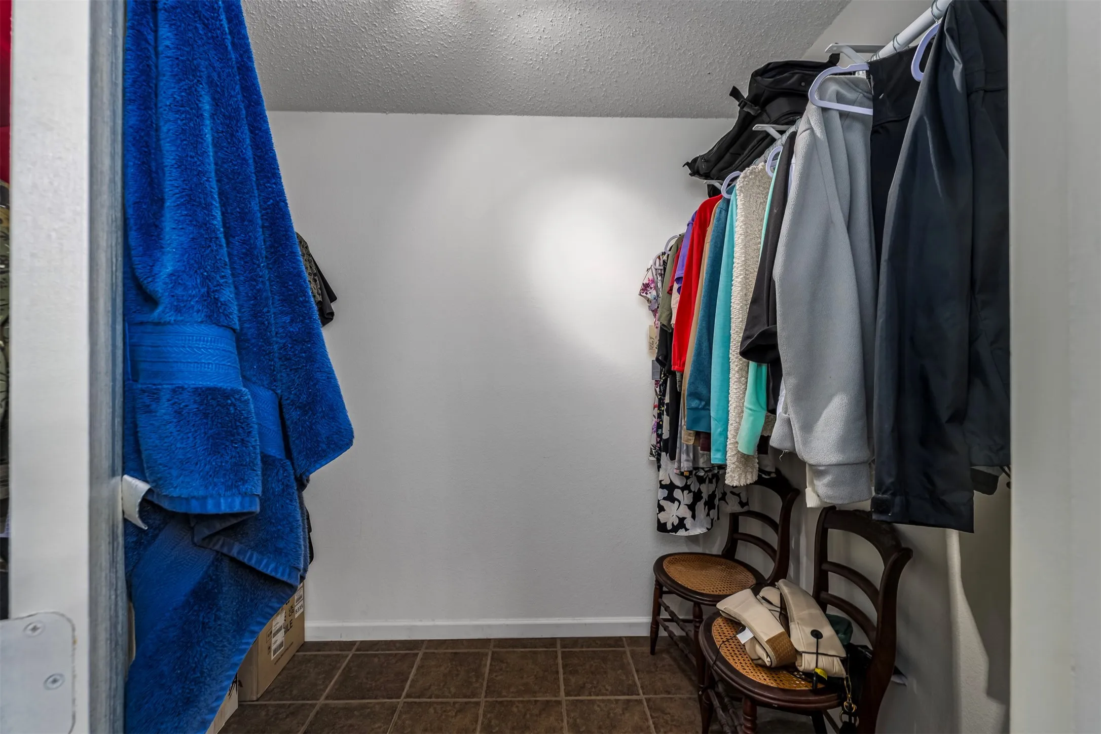 Walk in closet featuring dark tile patterned floors
