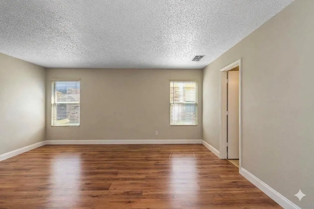 Empty room featuring dark wood-style flooring, healthy amount of natural light, and a textured ceiling