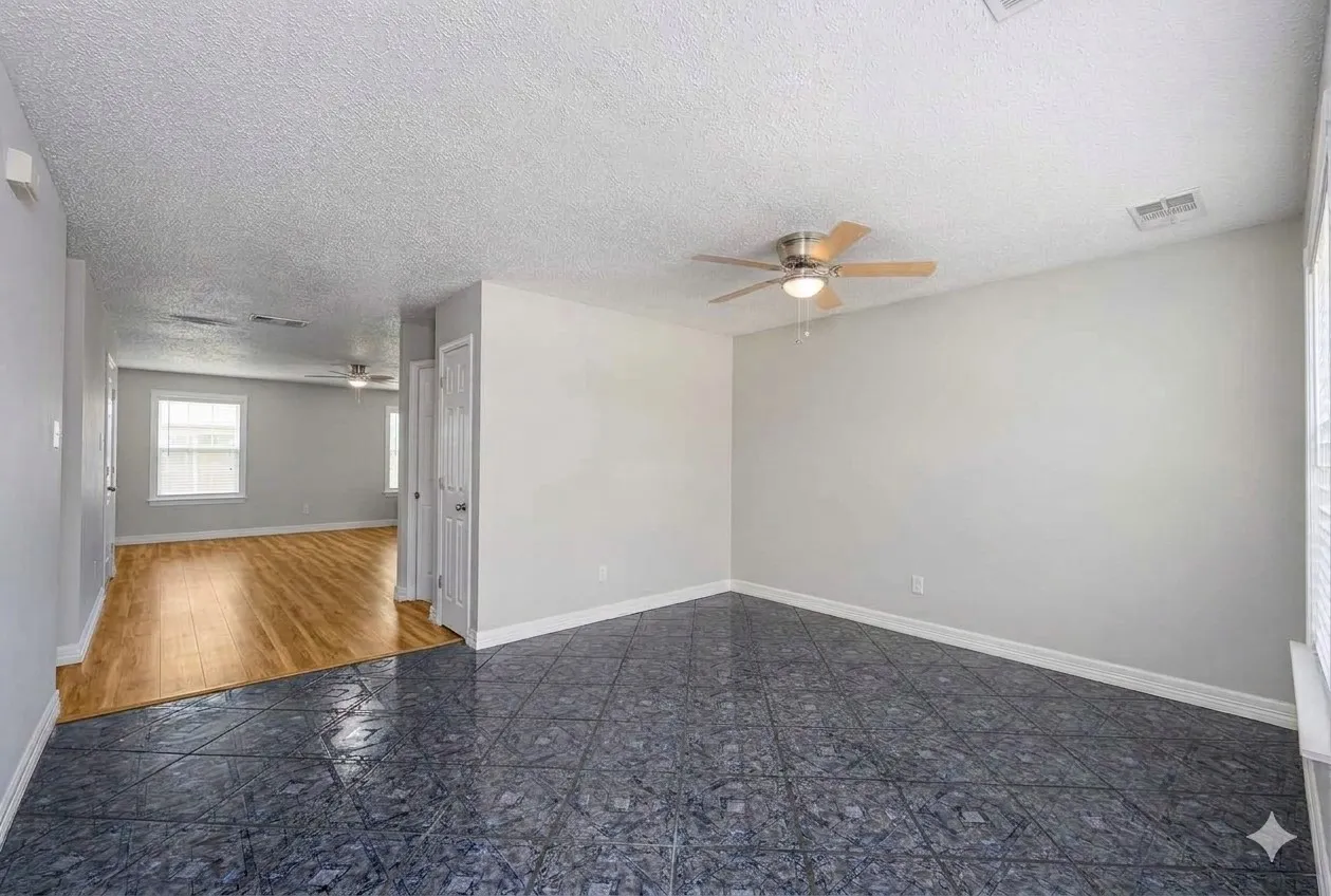 Unfurnished room with a ceiling fan and a textured ceiling