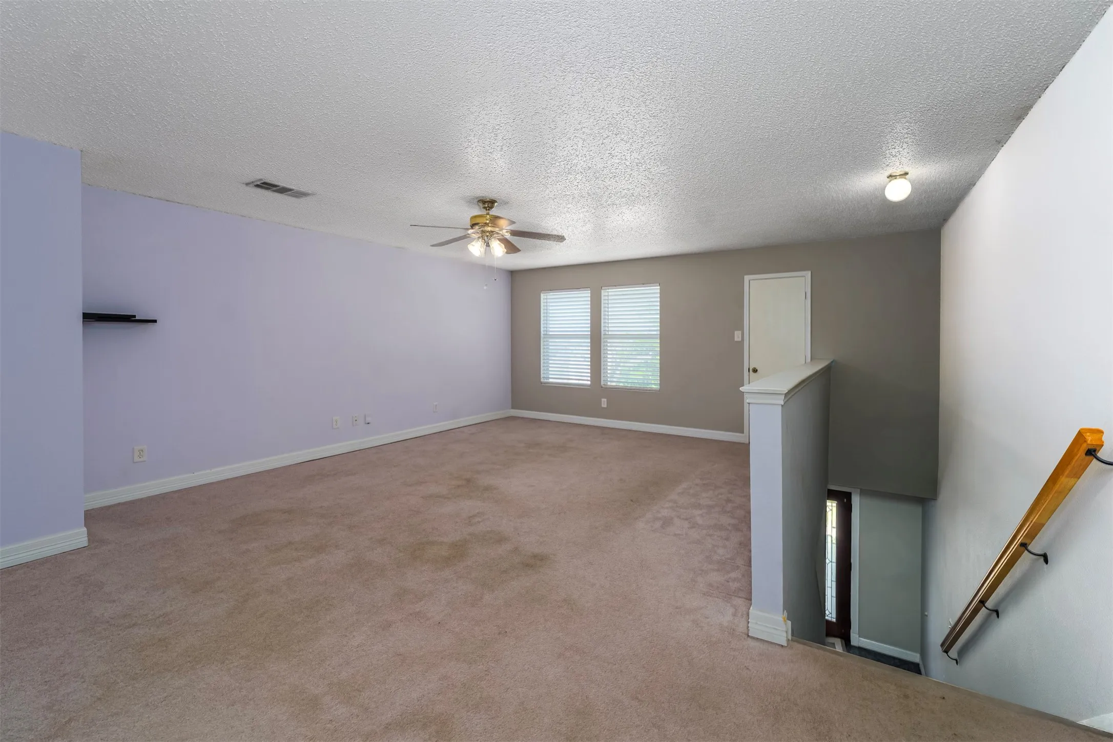 Unfurnished room with light carpet, a textured ceiling, and a ceiling fan