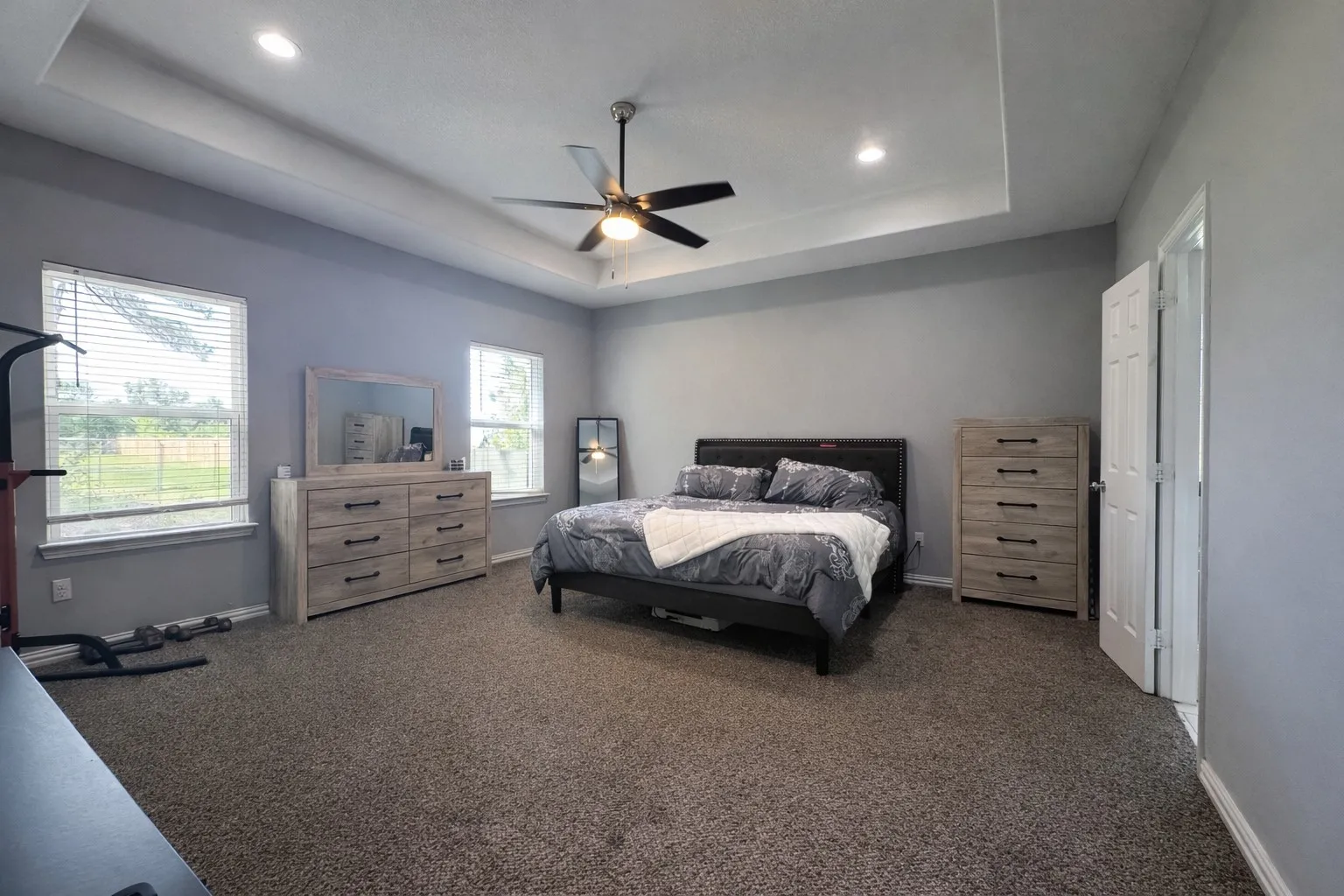 Bedroom with carpet, a tray ceiling, a ceiling fan, and recessed lighting