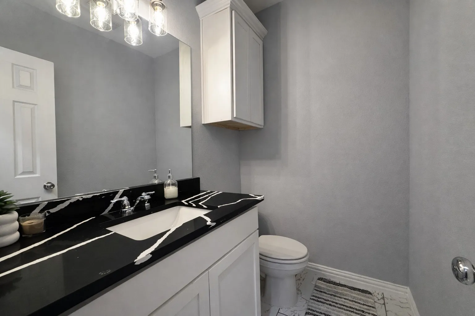 Bathroom featuring vanity and marble look tiles