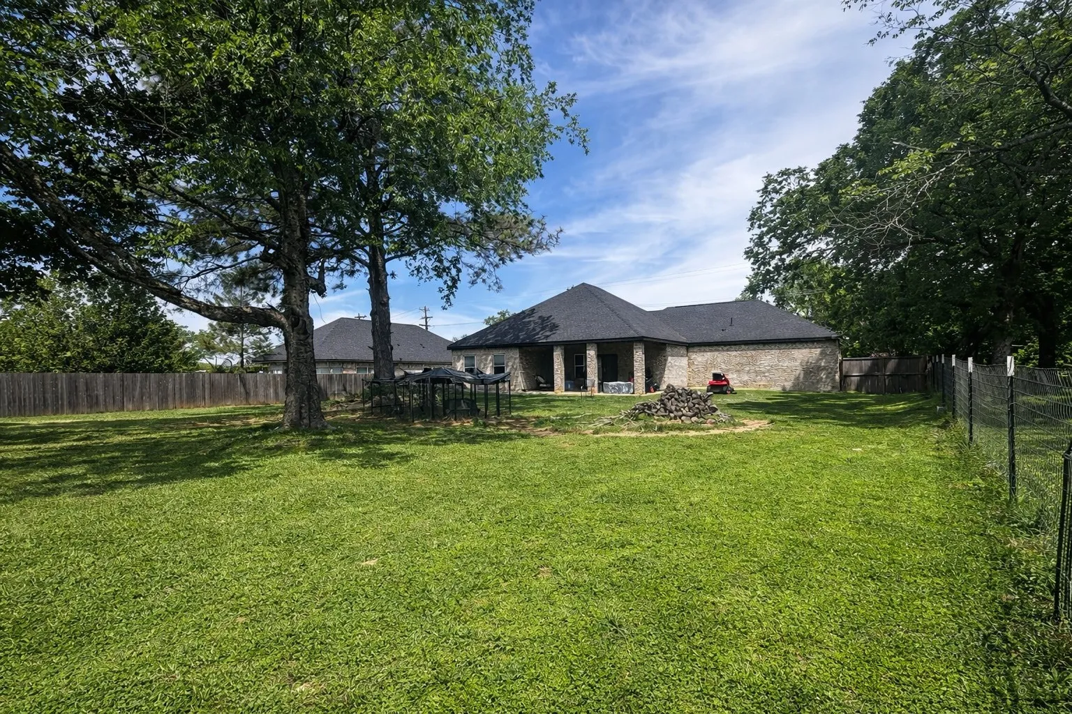 Back of house featuring a patio, a fenced backyard, and brick siding