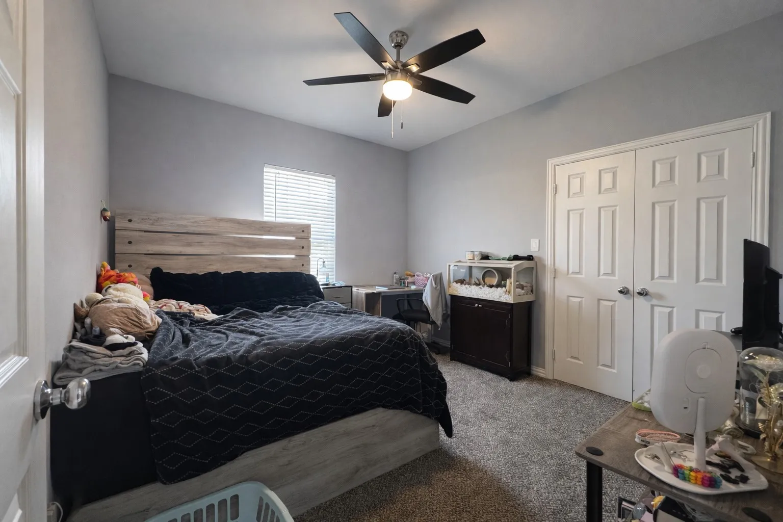 Bedroom featuring light carpet, ceiling fan, and a closet