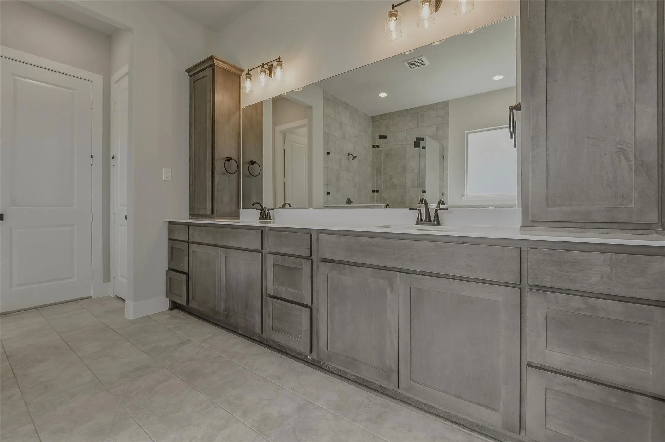Dual vanity with gray wood-finish cabinetry and white countertops