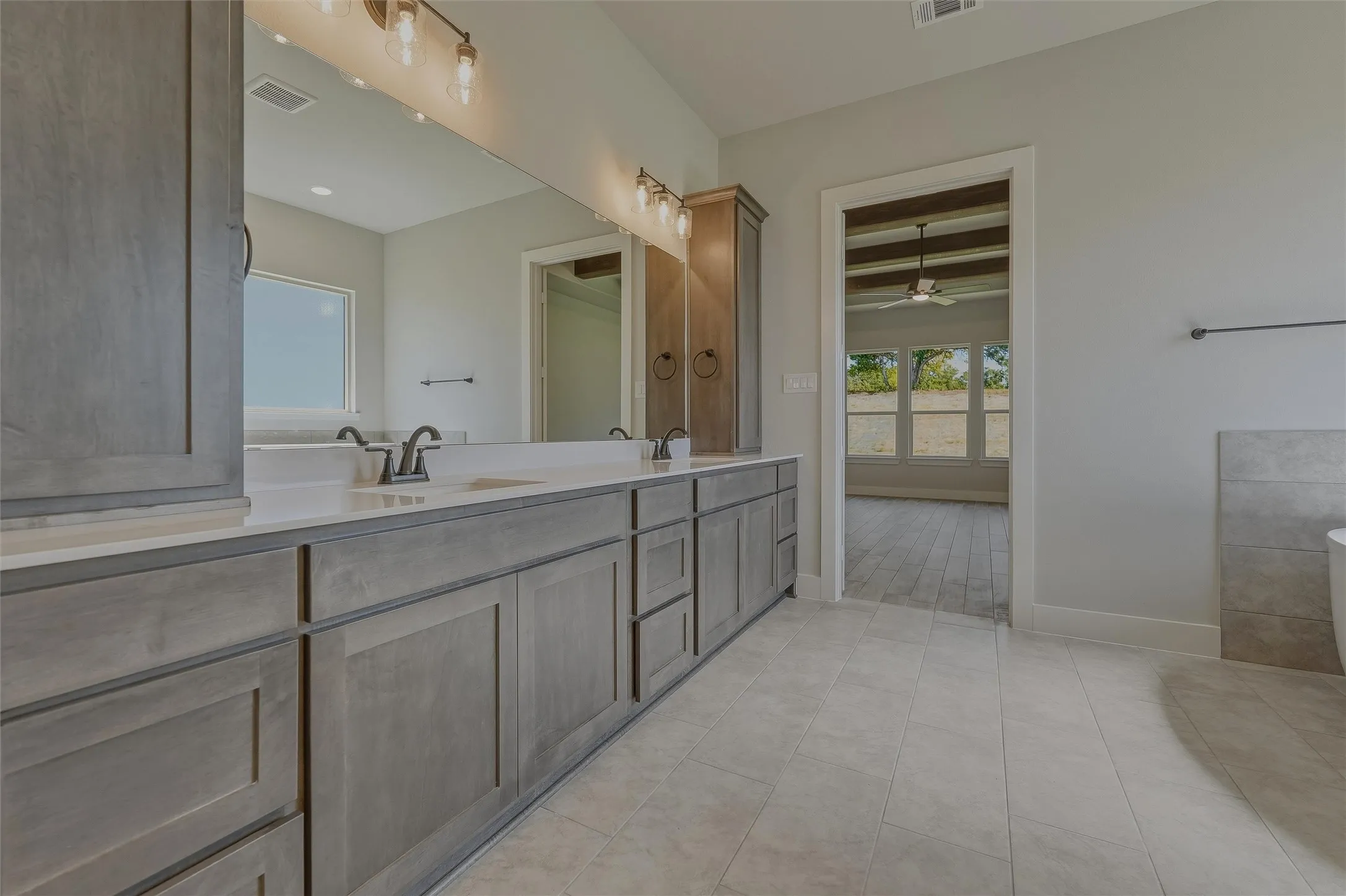 Dual vanity with gray wood-finish cabinetry and white countertops