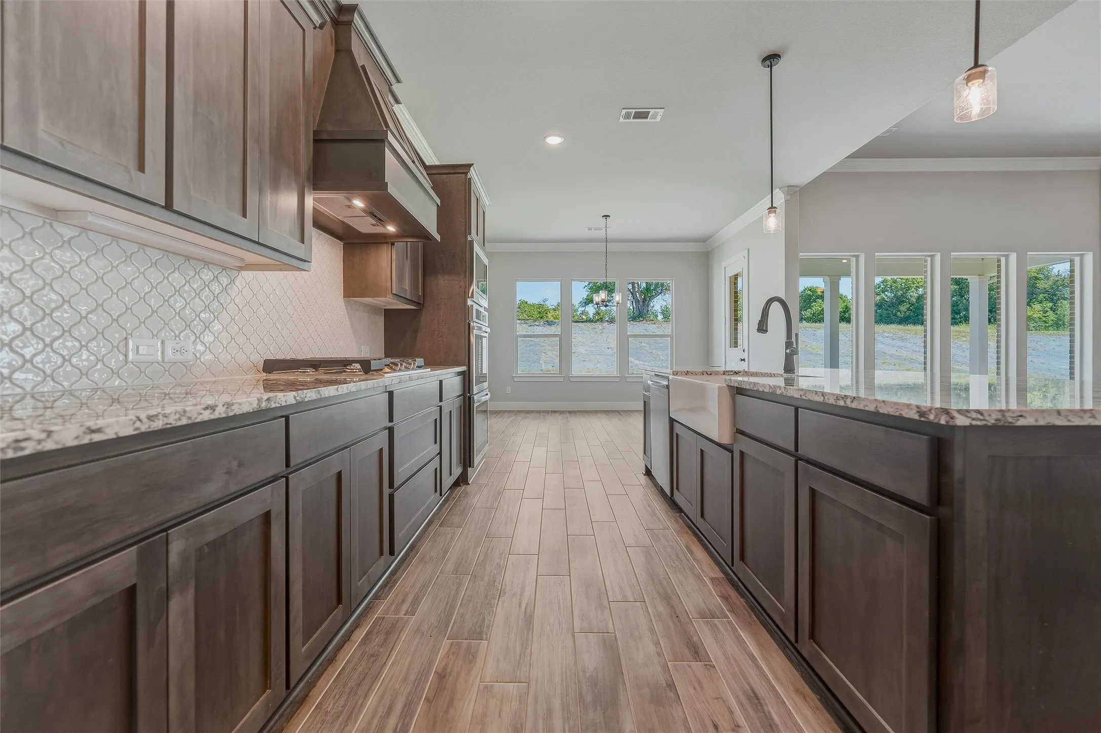 Gourmet kitchen featuring dark wood cabinetry, granite countertops, and a decorative tile backsplash