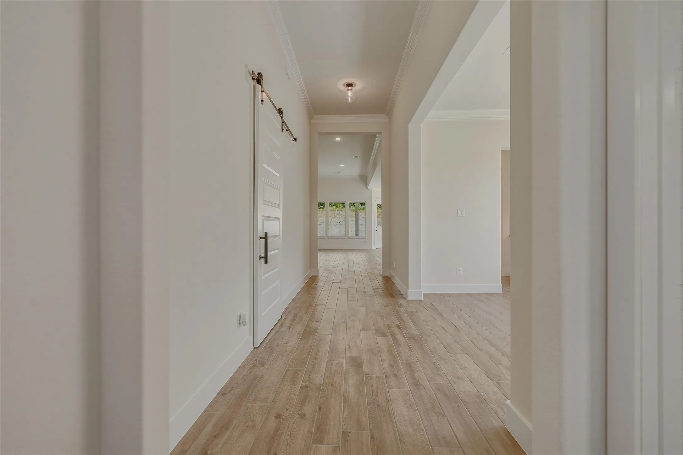 Hallway featuring wood-finish flooring, white baseboards, and light-toned​​‌​​​​‌​​‌‌​‌‌​​​‌‌​‌​‌​‌​​​‌​​ walls