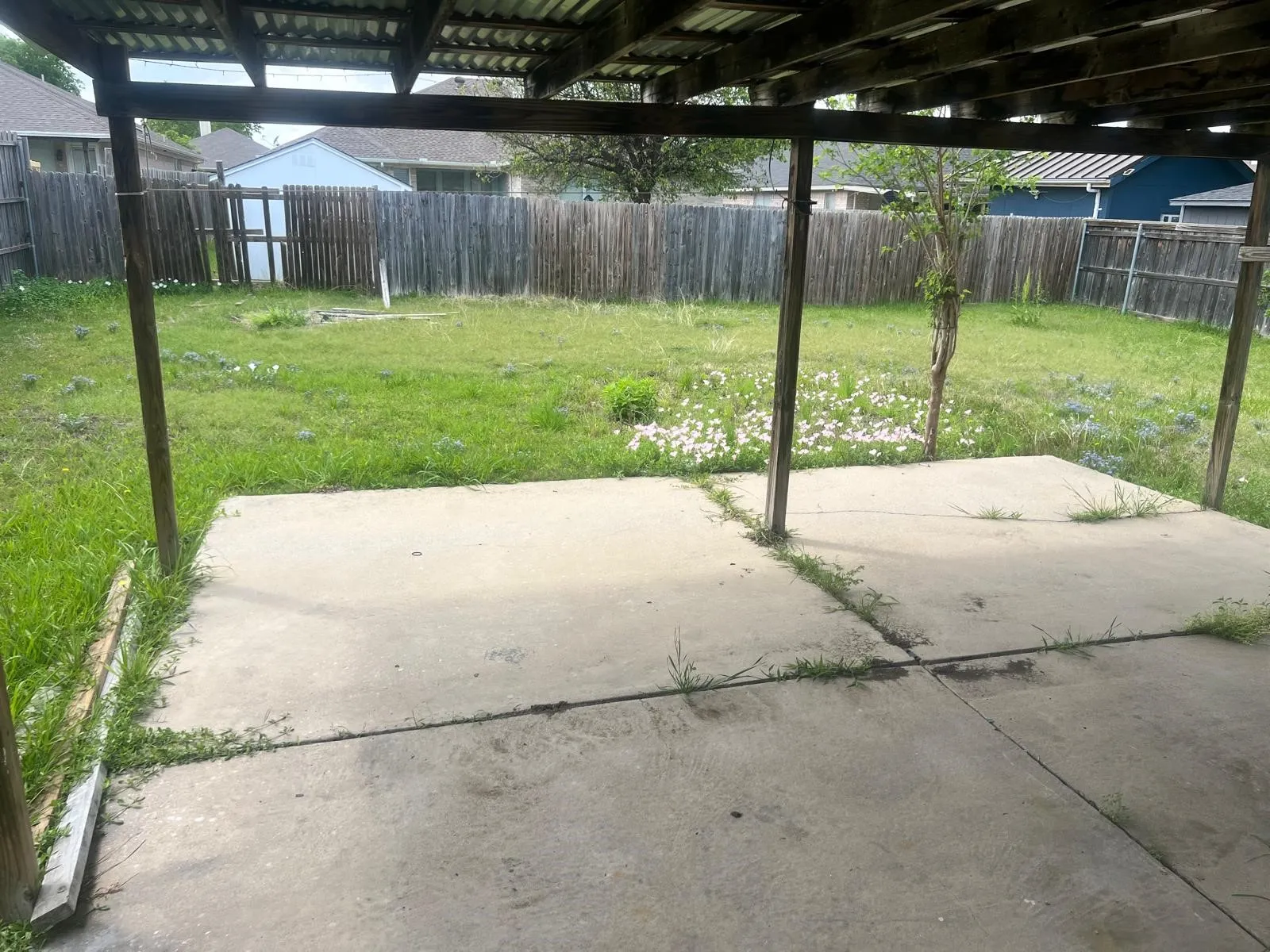 Covered patio area featuring a concrete slab and exposed wood beam ceiling