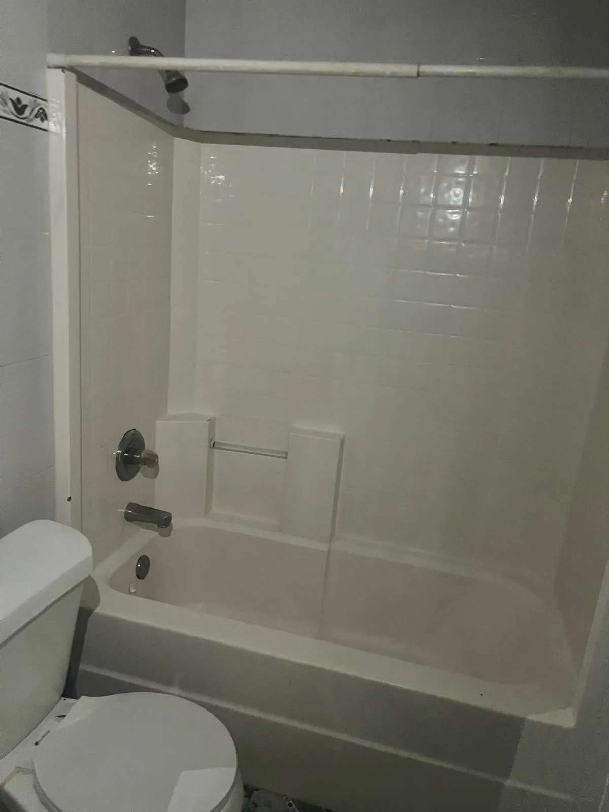 White fiberglass tub and shower combination with chrome fixtures