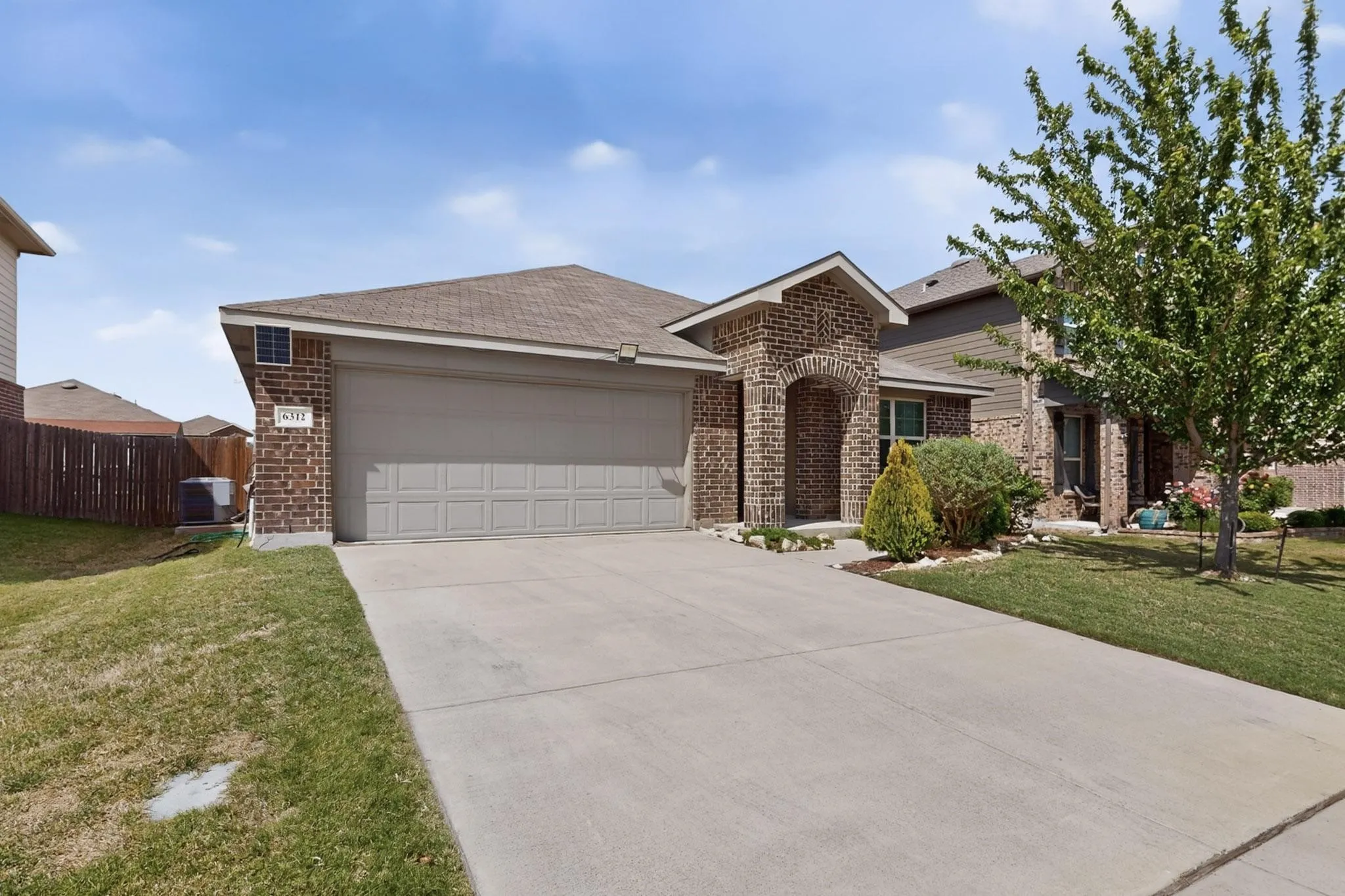 Ranch-style house with brick siding, an attached garage, concrete driveway, and a shingled roof